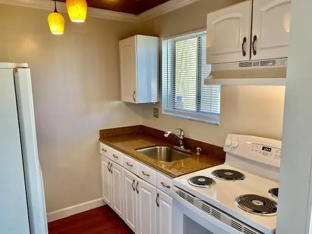 a kitchen with a sink a stove and cabinets