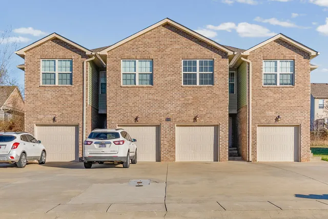 a view of a car parked in front of a brick house