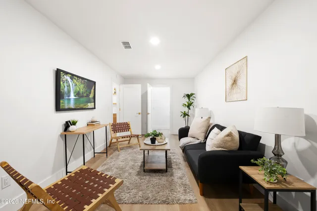 a living room with furniture and wooden floor