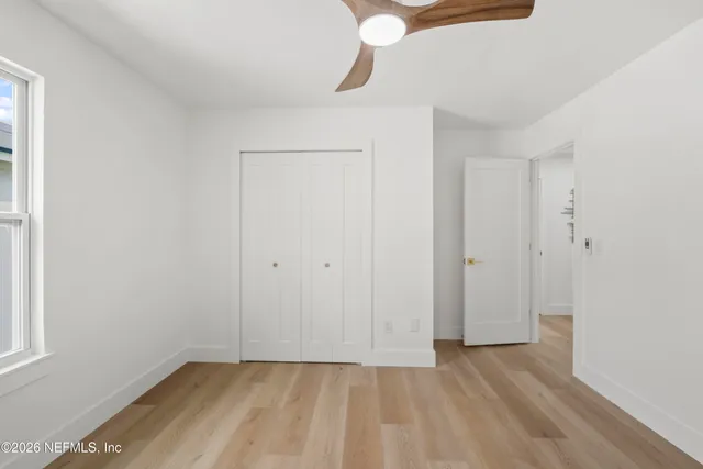 a view of an empty room with wooden floor