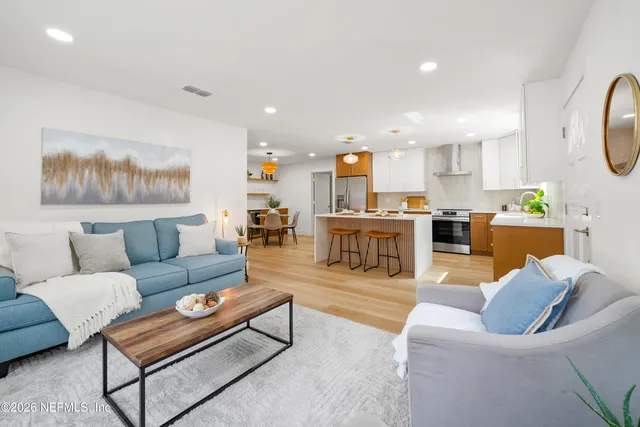 a living room with furniture and kitchen view