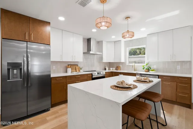 a kitchen with a refrigerator a stove a sink and white cabinets