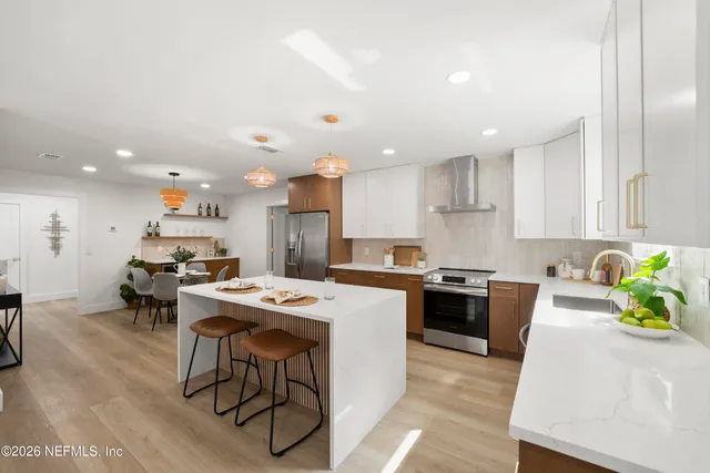 a large kitchen with kitchen island a sink table and chairs