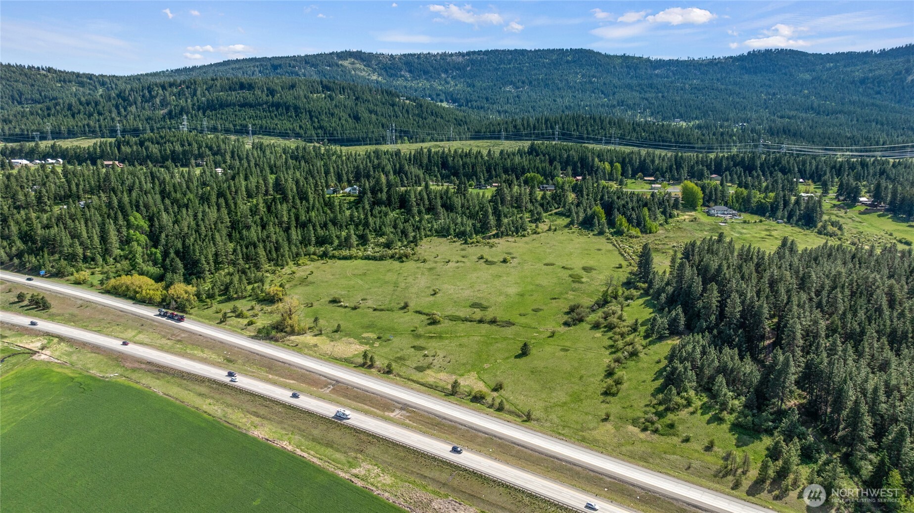 66-x4 Upper Peoh Point Road Cle Elum, WA 98922 - Photo 23 of 32 a view of a green field with mountains in the background