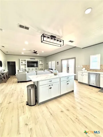 a large white kitchen with a table and chairs