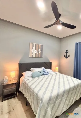 a bedroom with a bed and a flat tv screen on wall