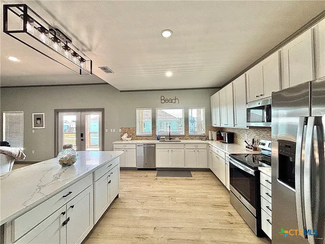 a large kitchen with stainless steel appliances lots of counter top space