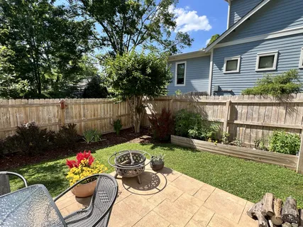 a view of a backyard with furniture and plants