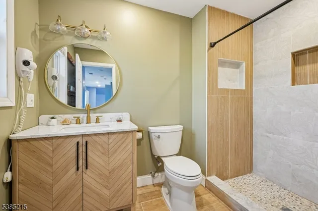 a bathroom with a toilet sink vanity and mirror