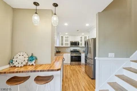 a kitchen with stainless steel appliances granite countertop a sink a refrigerator and a stove