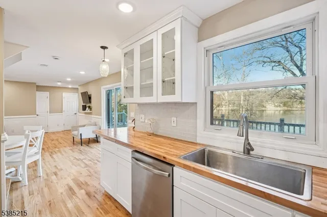 a kitchen with a sink wooden floor and a large window