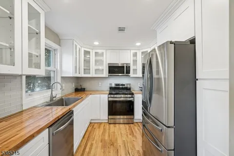a kitchen with granite countertop stainless steel appliances and wooden cabinets
