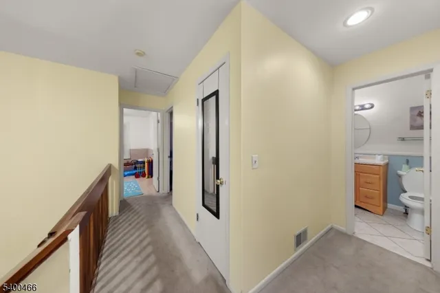 a view of a hallway with a livingroom and a bathroom