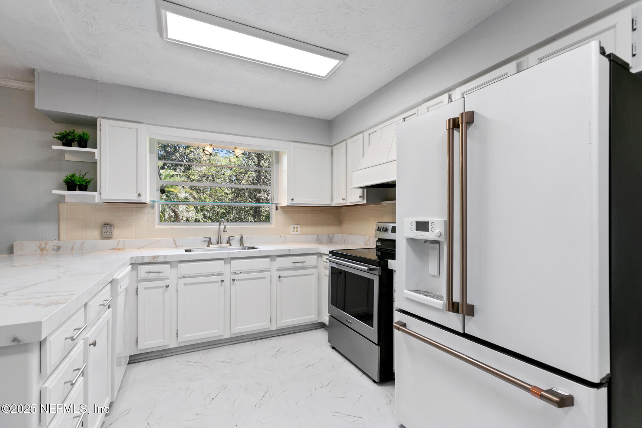 12657 Aladdin Road Jacksonville, FL 32223 - Photo 11 of 47 a kitchen with white cabinets and white appliances