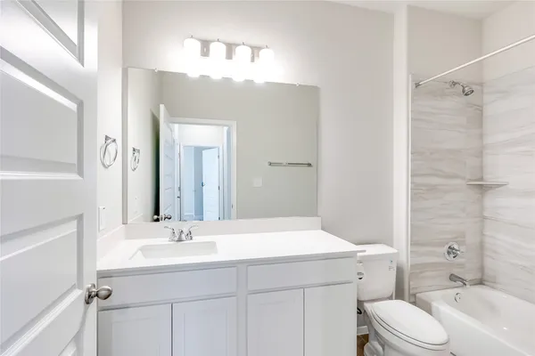 a bathroom with a sink toilet double vanity and shower