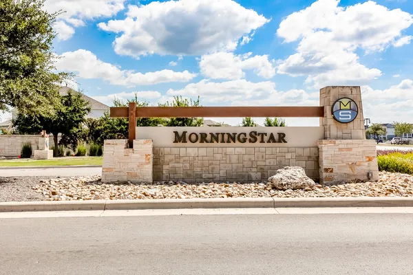 a sign board with parking space in back