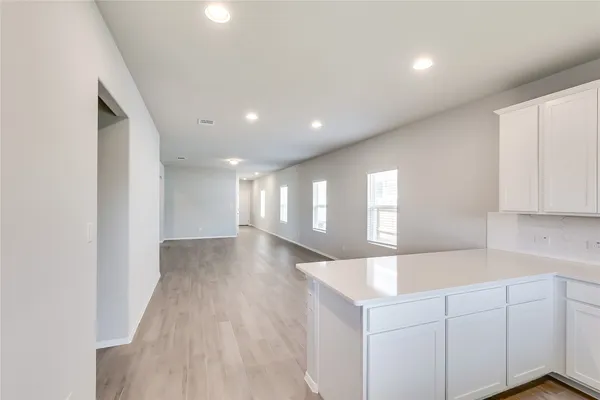 a view of entryway and kitchen with wooden floor