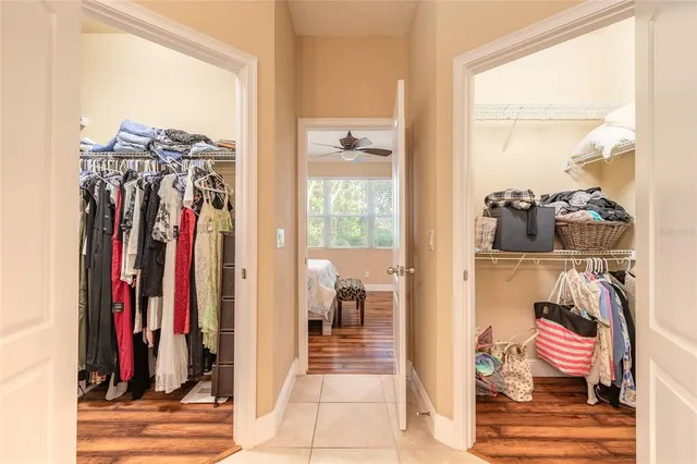 a view of a walk in closet with clothes and shoes