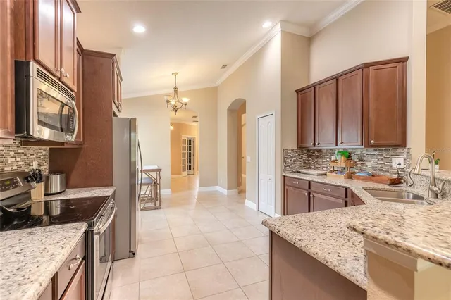 a kitchen with kitchen island granite countertop a sink stove and refrigerator