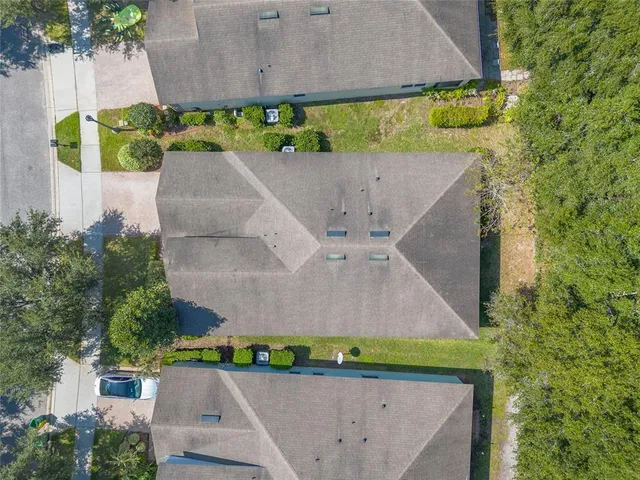 an aerial view of a house with a garden and a car parked