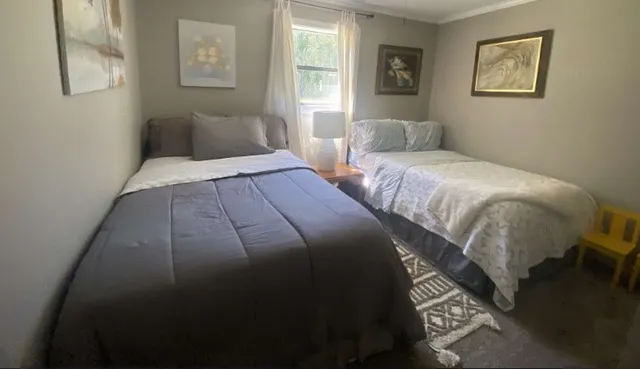 a bedroom with two beds and a window