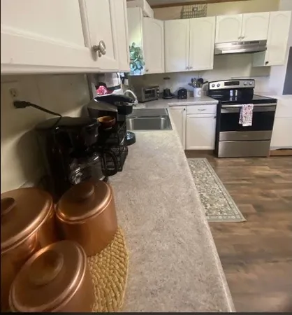 a kitchen with a sink a stove and cabinets