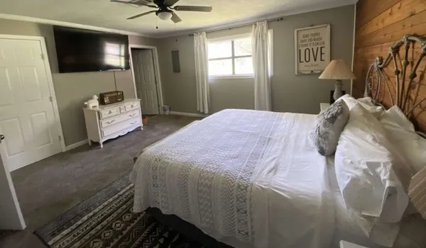 a bedroom with a bed and a flat screen tv