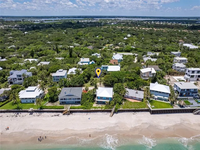 an aerial view of a house with a yard and mountain