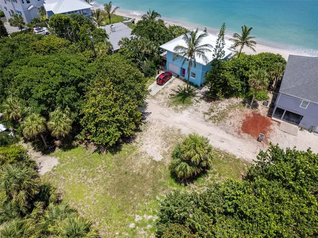 an aerial view of a house with a yard and lake view