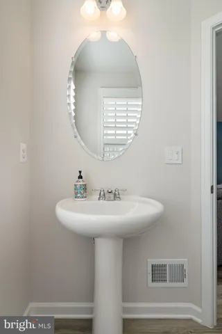 a bathroom with a sink a mirror and a light fixture