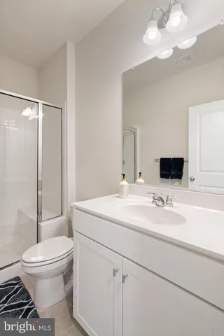 a bathroom with a sink a toilet and a large mirror