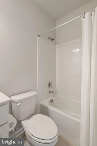 a white toilet and shower sitting next to a bathroom sink