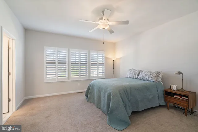 a spacious bedroom with a bed a chandelier and a window
