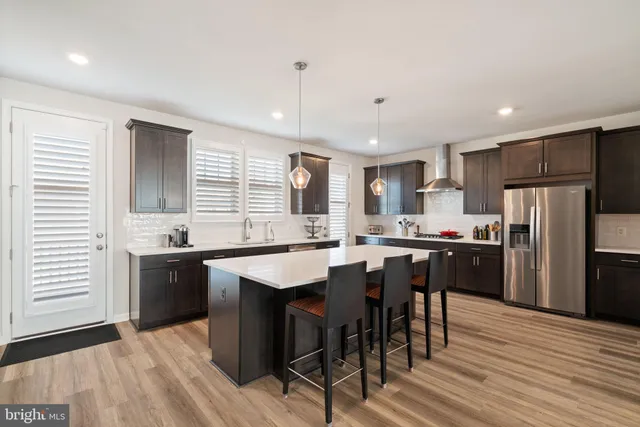 a large kitchen with kitchen island a sink table and chairs