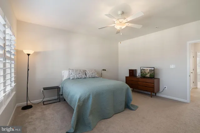 a spacious bedroom with a bed and a ceiling fan