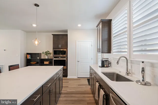 a kitchen with a sink a counter top space stainless steel appliances and cabinets