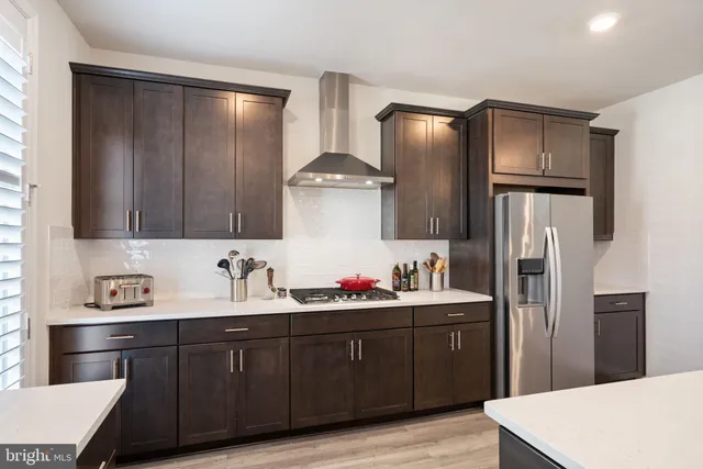 a kitchen with stainless steel appliances a refrigerator sink and wooden cabinets