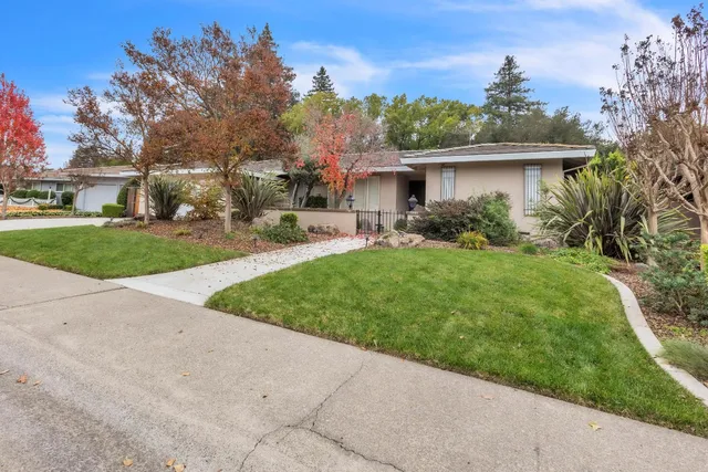 a view of backyard with table and chairs and wooden fence