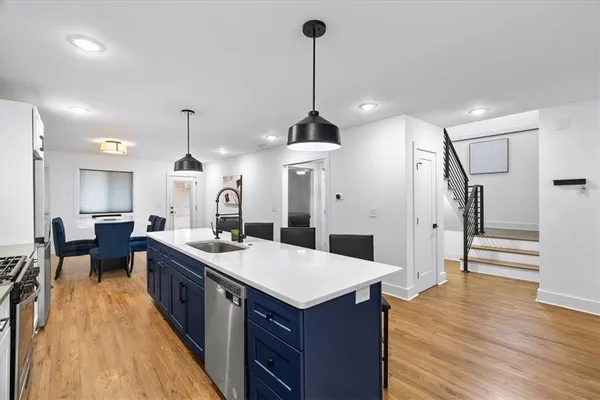 a kitchen with a stove a refrigerator a sink dishwasher with a dining table and chairs