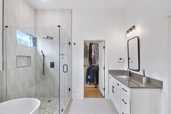 a spacious bathroom with a granite countertop sink mirror and shower
