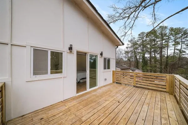 a view of a roof deck with wooden floor and fence next to a yard
