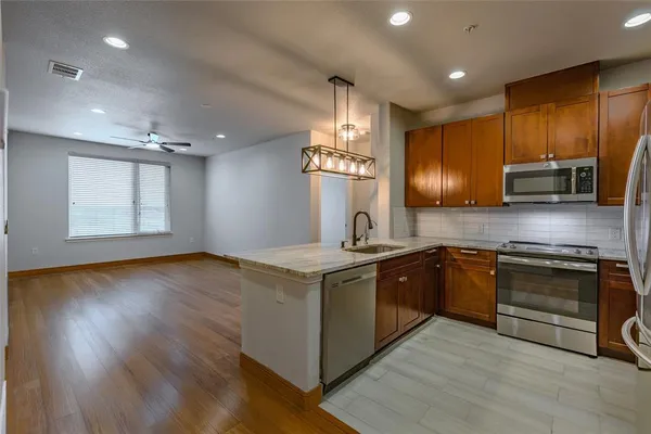 a kitchen with stainless steel appliances granite countertop a stove a sink and a microwave