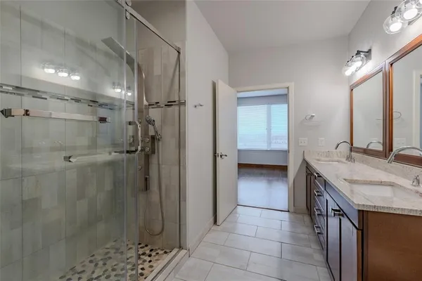 a bathroom with a granite countertop shower sink and mirror