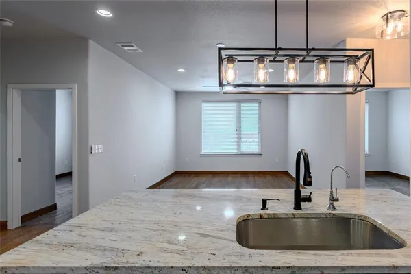 a kitchen with a sink and a stove with wooden floor