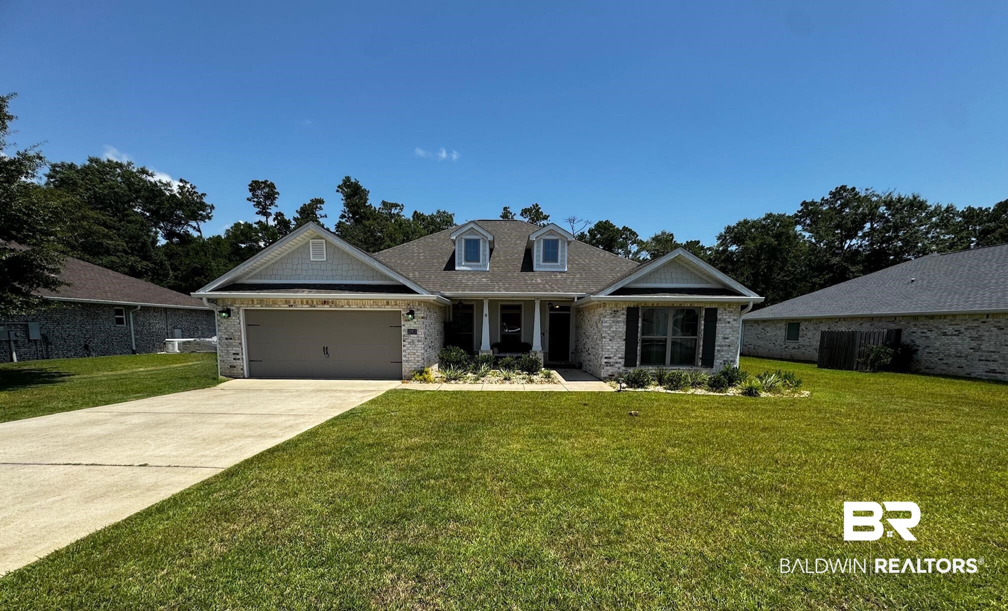 32915 Arbor Ridge Circle Lillian, AL 36549 - Photo 2 of 26 View of front of property with a front lawn, an attached garage, brick siding, and driveway