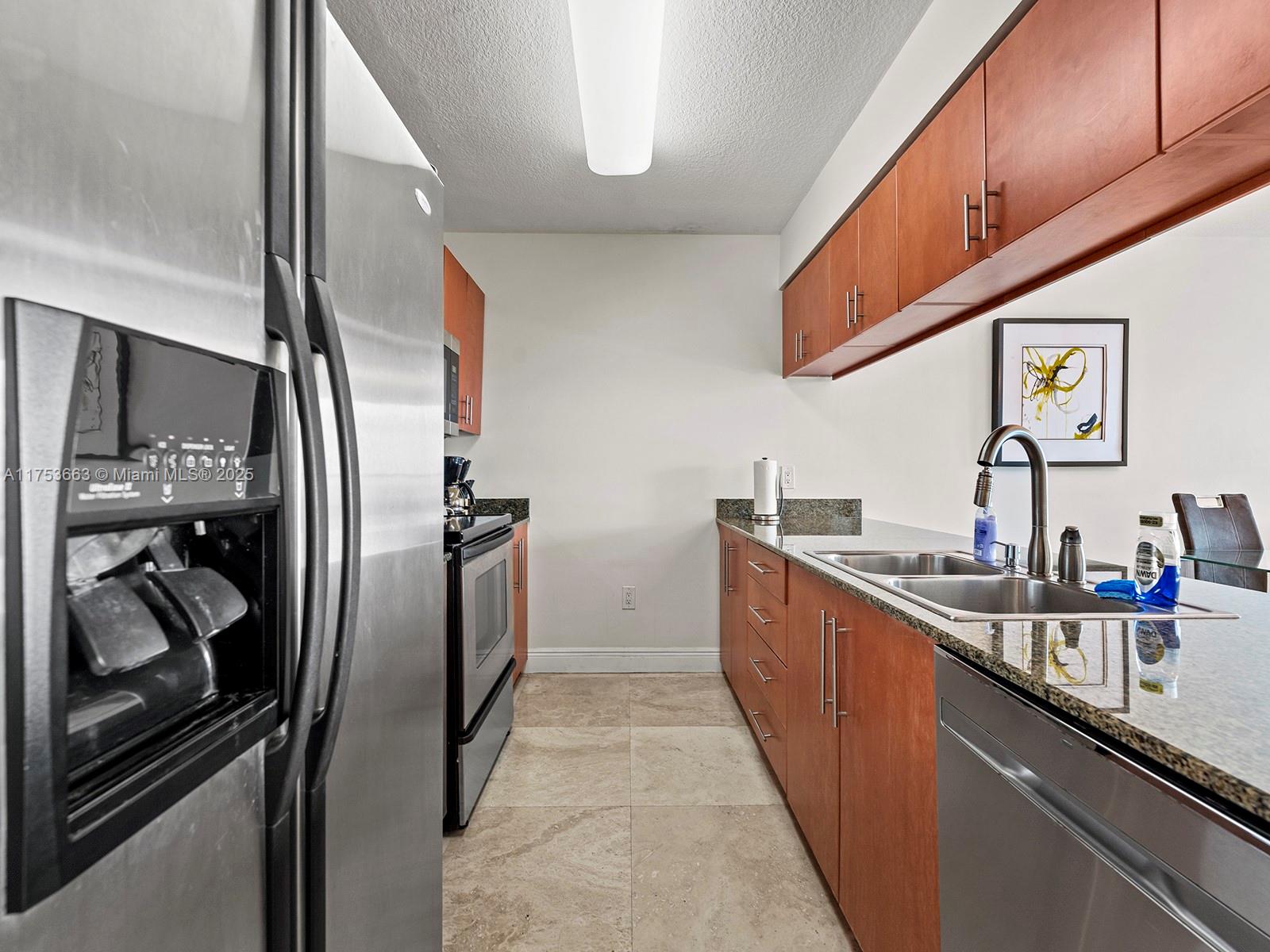1200 Brickell Bay Drive, Unit 4019 Miami, FL 33131 - Photo 11 of 32 a kitchen with stainless steel appliances granite countertop a sink and a refrigerator