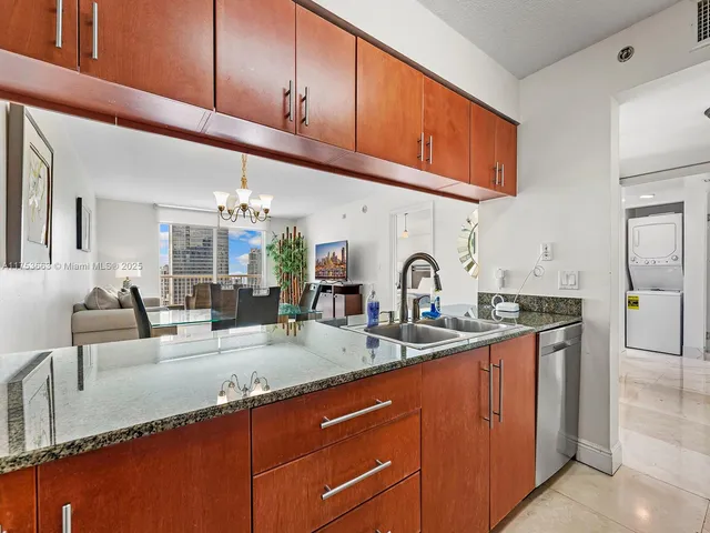 a kitchen with stainless steel appliances granite countertop a sink a stove and cabinets