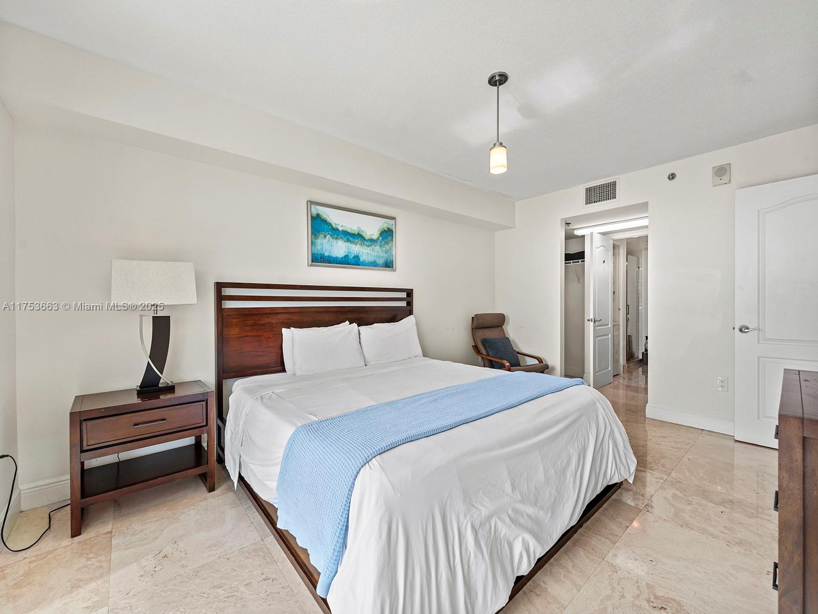 1200 Brickell Bay Drive, Unit 4019 Miami, FL 33131 - Photo 21 of 32 a bedroom with bed and a night stand