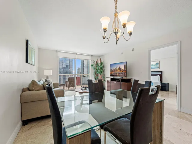 a view of a dining room with furniture a chandelier and wooden floor