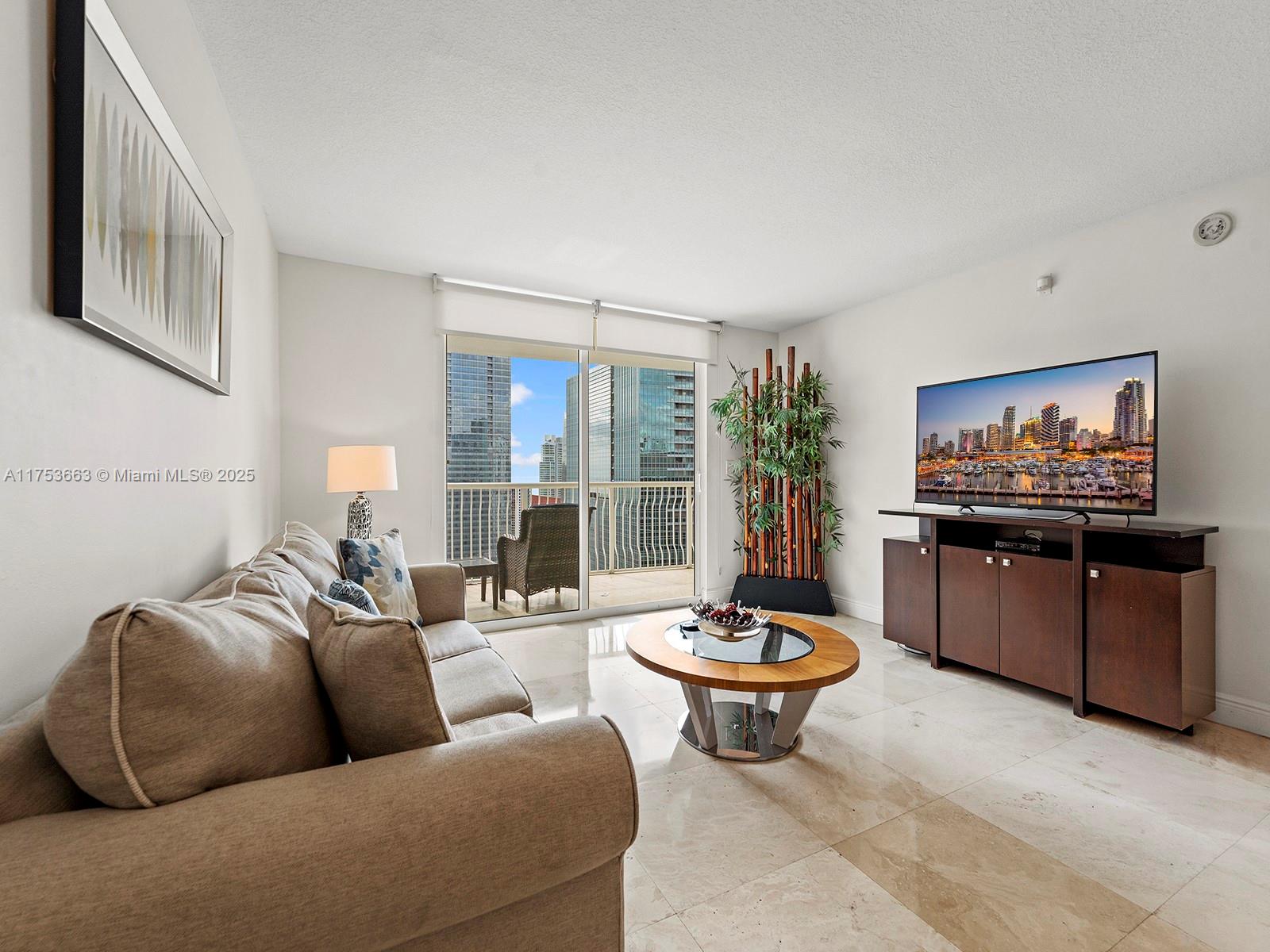 1200 Brickell Bay Drive, Unit 4019 Miami, FL 33131 - Photo 8 of 32 a living room with furniture and a flat screen tv